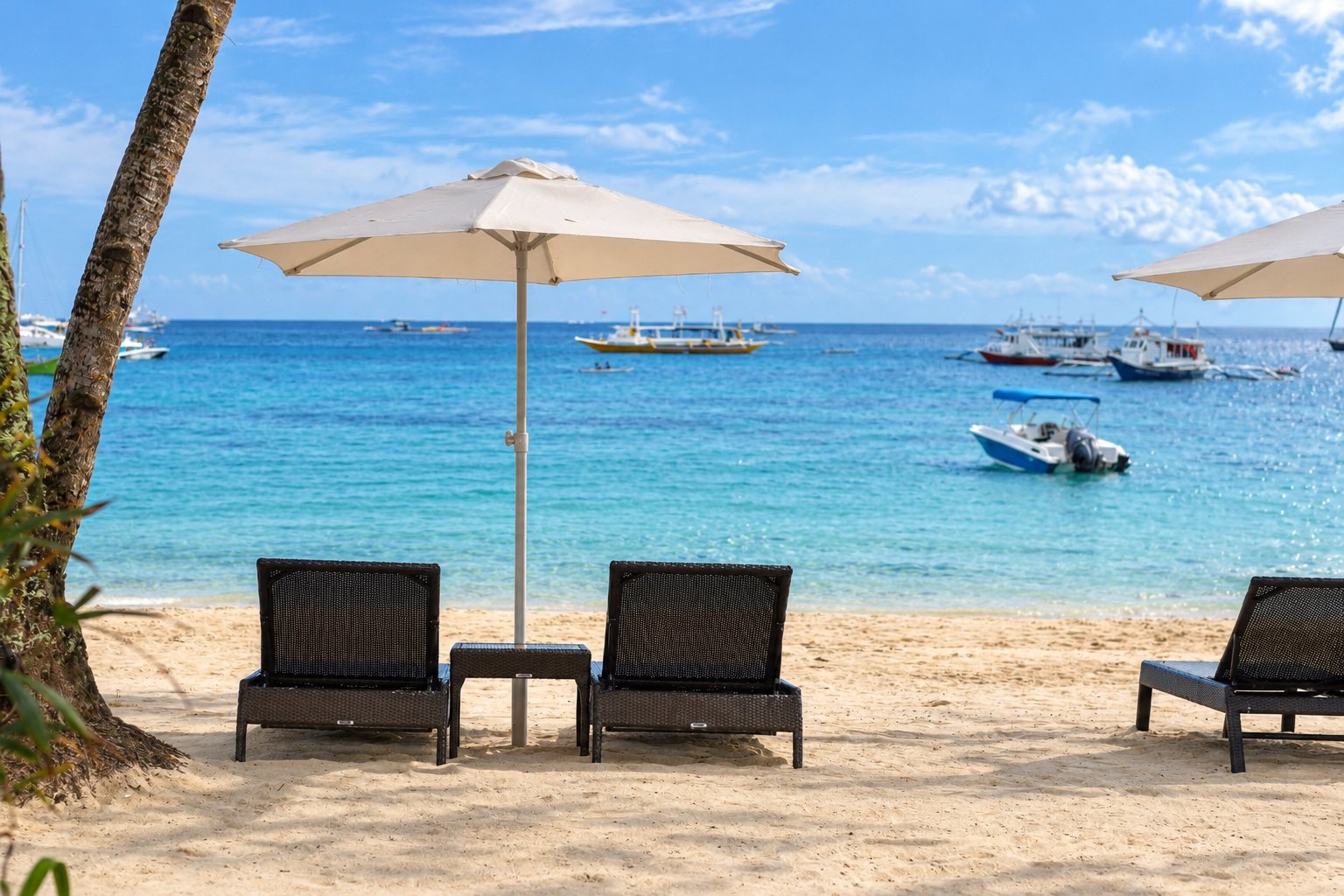Sun loungers and an umbrella on the beach facing the bay